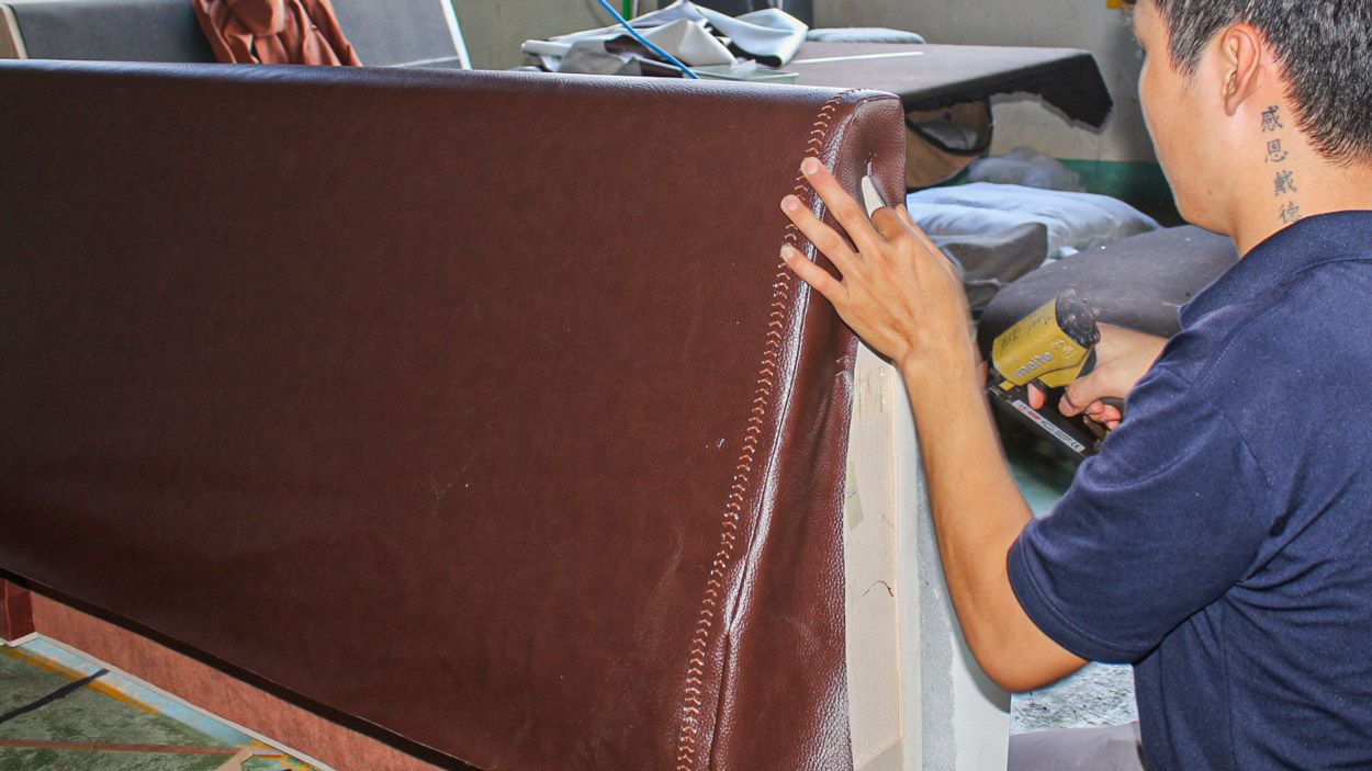 Skilled craftsman hand-finishing upholstered furniture